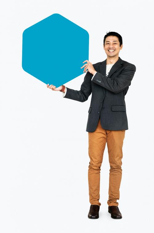 Cheerful man showing a blank blue hexagon shaped board - 490997