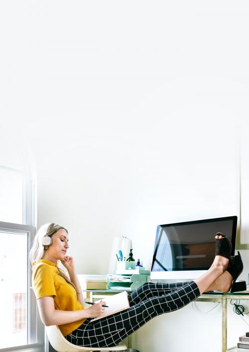 Casual woman in an office with headphones - 2205359