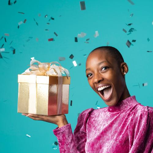 Happy black woman holding a gift box - 2257717