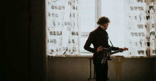 Man playing a guitar in his room social banner - 2024966