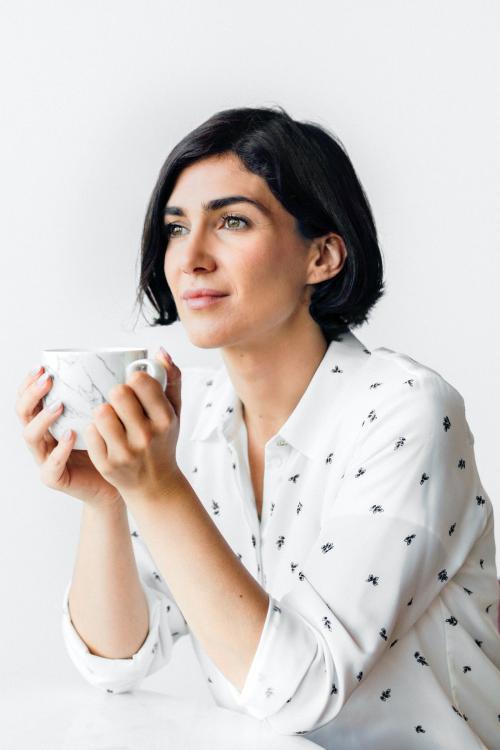 Woman sipping coffee at a cafe - 2030306