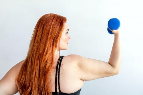 Rear view of active woman with dumbbell - 2041657