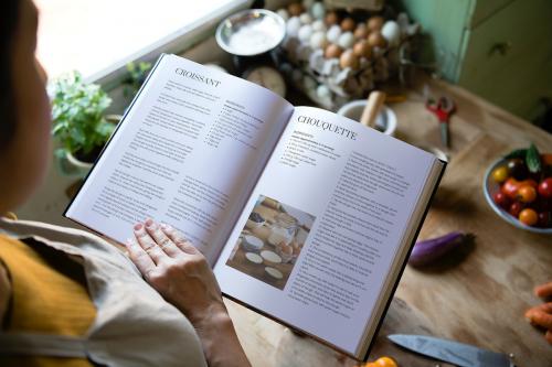 Happy woman reading a cookbook in the kitchen - 484491