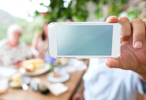 Man holding a smartphone and taking a selfie - 484610