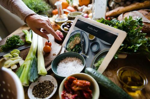 A digital tablet in the middle of a busy kitchen bench - 484818