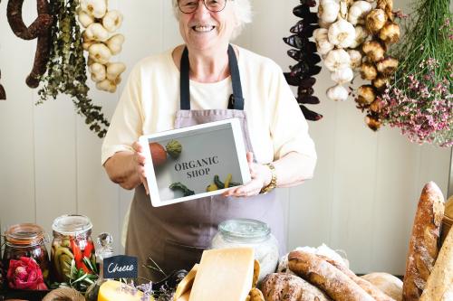 Senior woman selling organic gourmet produce at a deli - 485269