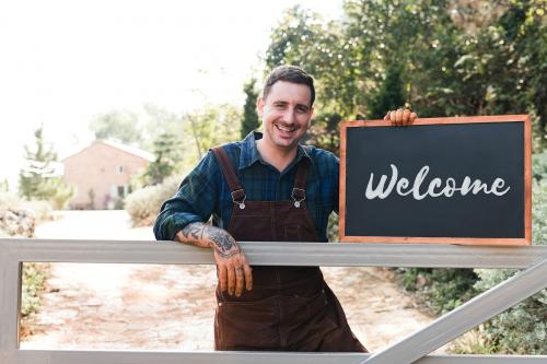 Farmer holding a blackboard welcoming sign - 485499