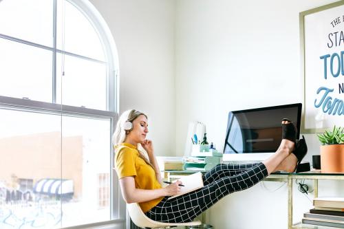 Casual woman in an office with headphones - 2205350