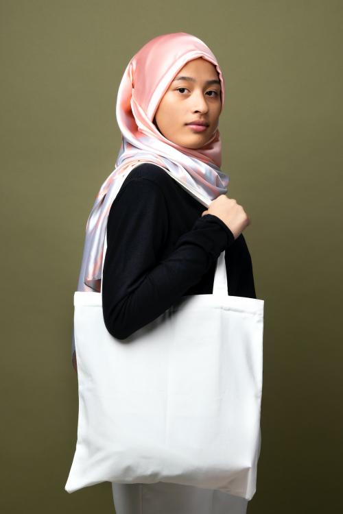 Muslim woman carrying a white tote bag - 2210594