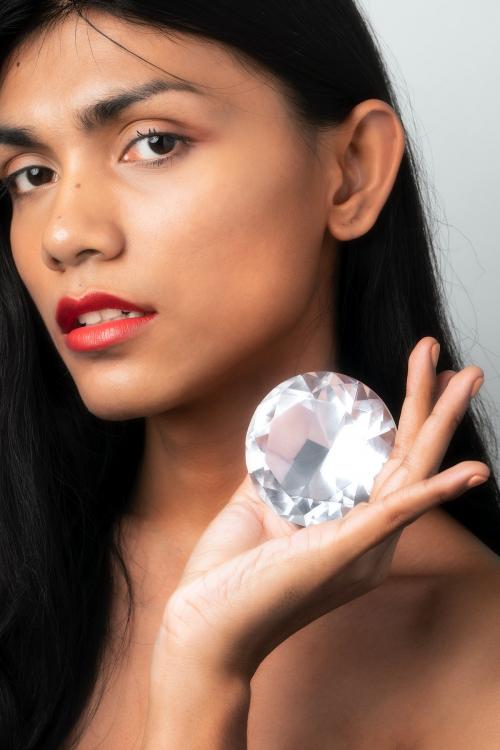 Beautiful woman holding a big diamond in her hand - 2223812