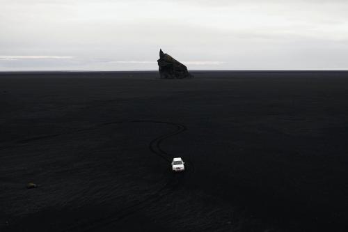 Car driving on black sand beach in Iceland - 2041460