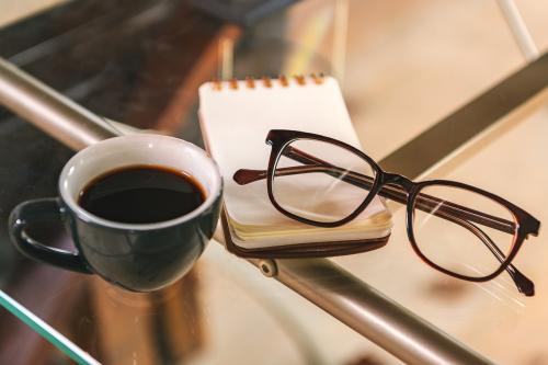 Glasses and a coffee cup on a glass table - 2203490