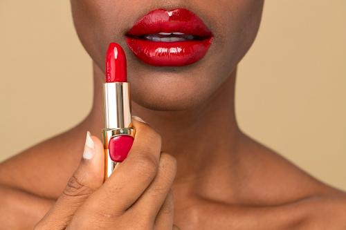 Black woman applying red lipstick on her lips - 2254272