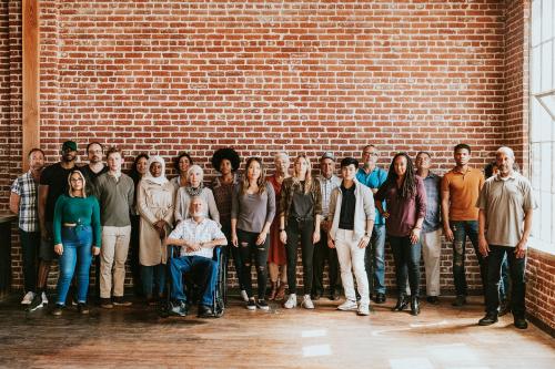 Group of diverse people standing in front of a brick wall - 1223728