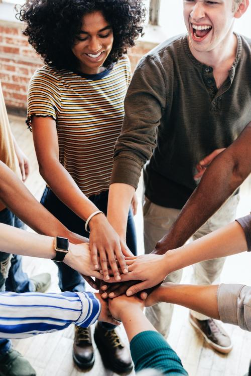 Group of diverse people stacking hands in the middle - 1223791