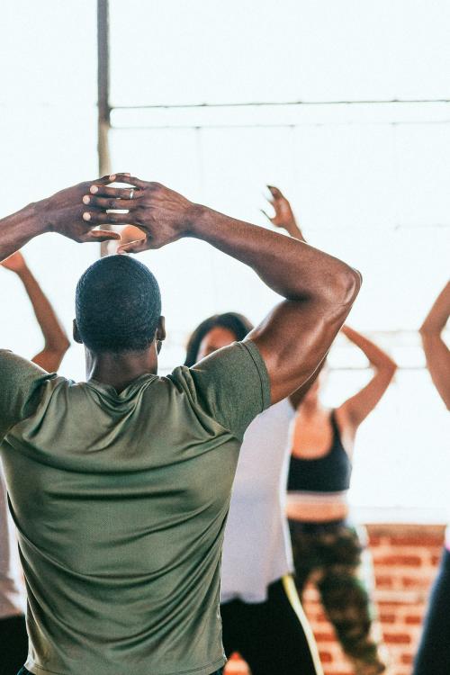 Trainer and his students stretching in a studio - 1225129