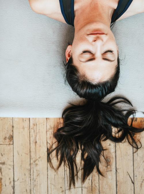 Fitness woman in a Shavasana pose - 1225373