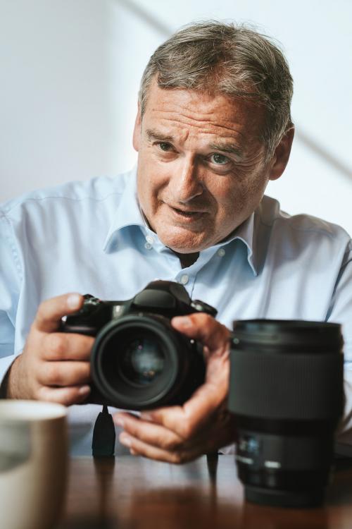 Senior photographer using a camera in a studio - 1225459