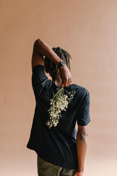 Black man carrying a bouquet of flowers on his back - 1226338