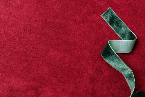 Velvet green ribbon on a red background - 1231331