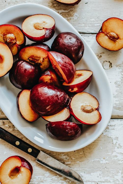 Sliced organic plums in a bowl - 893658