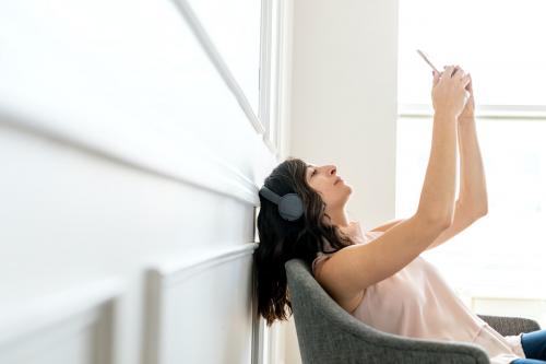 Woman wearing headphones and taking a selfie - 1224234