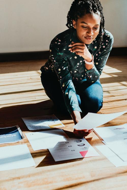 Businesswoman planning a marketing strategy on a wooden floor - 1226703