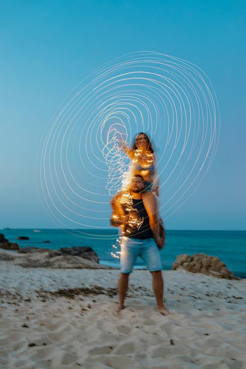 Woman riding on man's shoulder at the beach - 1228441