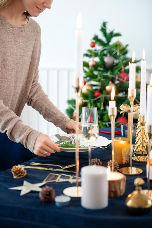 Blond woman setting up a Christmas dining table - 1231726