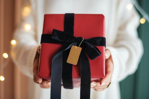 Woman holding a red present with a card - 1231745