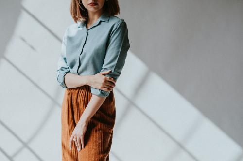 Woman in a blue shirt by the white wall - 1235420