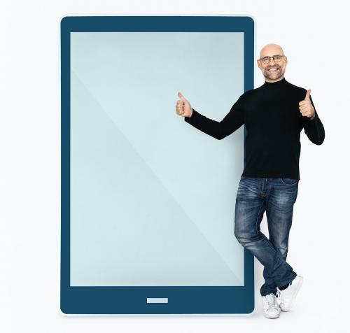 Cheerful man standing beside a tablet - 475468