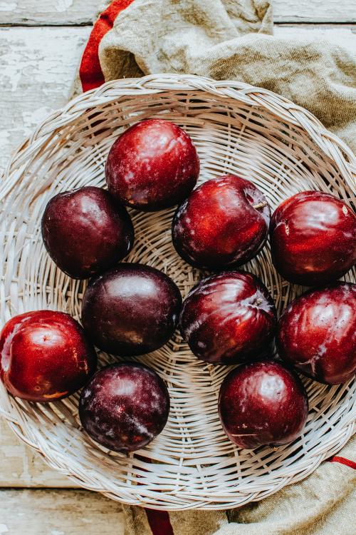 Oragnic plums in a basket - 893642