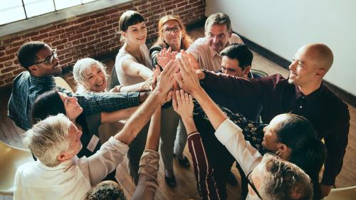 People joining hands in the air at a meeting - 1217850