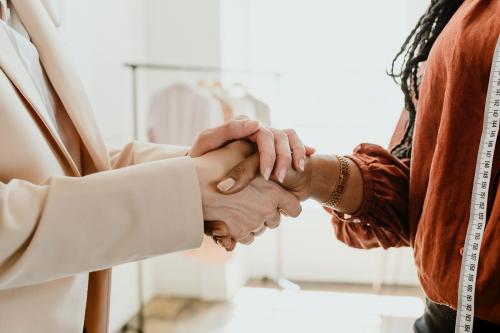 Two women shaking hands in a boutique - 1220975