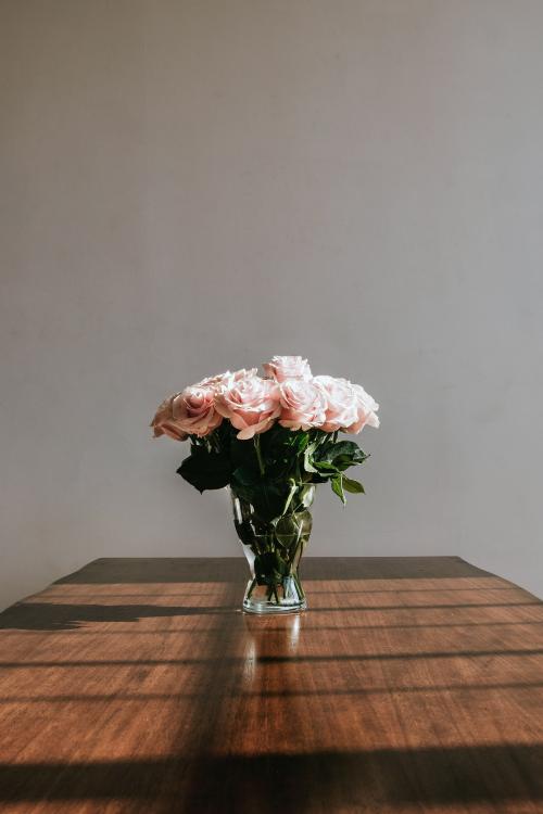 Beautiful pink roses in a vase on a table - 1221522