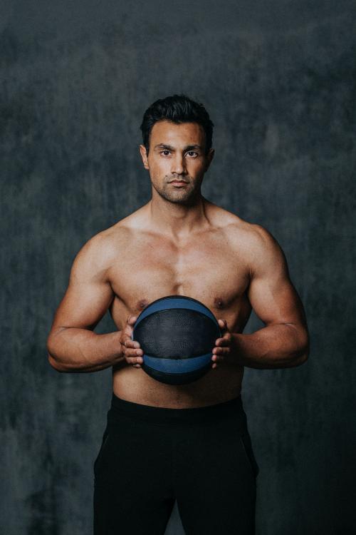 Shirtless muscular man holding a fitness ball - 1222536