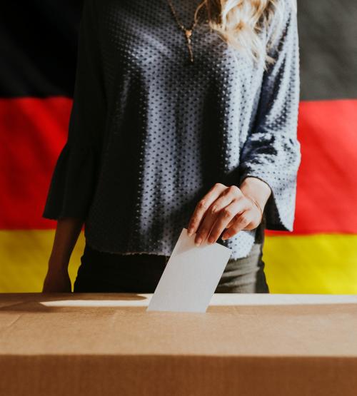 German woman casting her vote to a ballot box - 1223771