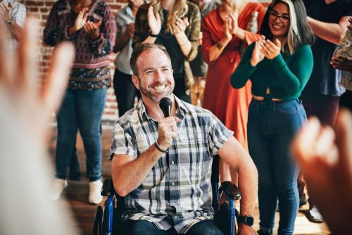 Handicapped man speaking on a microphone in a workshop - 1223871