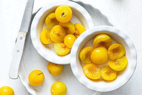 Fresh sliced mirabelle plums in a bowl - 1225293