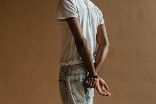 Black man standing by a beige background - 1226372