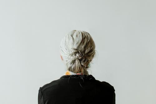 Senior woman facing a gray wall - 1226562