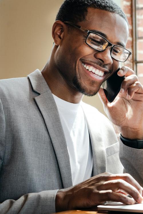 Businessman talking on a phone while using a laptop - 1226655