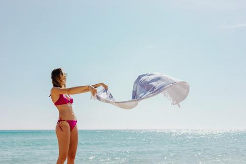 Girl in a pink bikini with a towel at the beach - 1228432