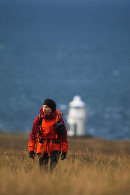 Female photographer at Vaternish Lighthouse on Isle of Skye, Scotland - 1233388