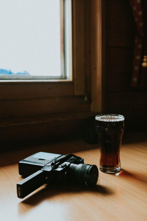 Vintage movie camera and a glass of dry stout - 598353