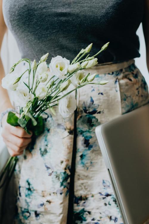 Woman holding white lisianthus and a laptop - 937454