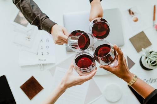 Colleagues toasting wine glasses at work - 1220755