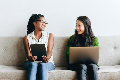 Diverse women sitting together using digital devices - 1226470