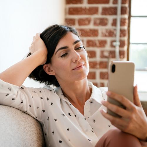 Woman on the couch using a smartphone - 1226572